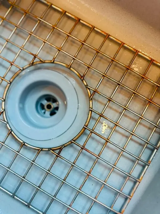 Sink grid and strainer before cleaning