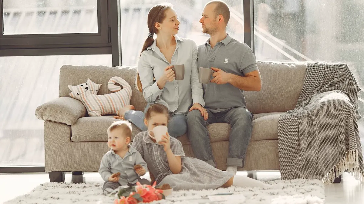 A couple with two young children relaxing with coffee in a bright living room